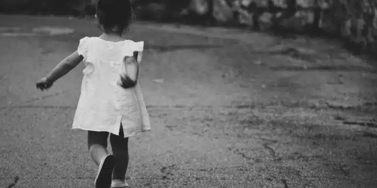 gray scale photography of girl walking towards destination