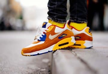 close-up photography of person wears brown-and-white Nike Air Max