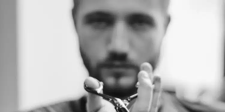 shallow focus photo of man holding scissors